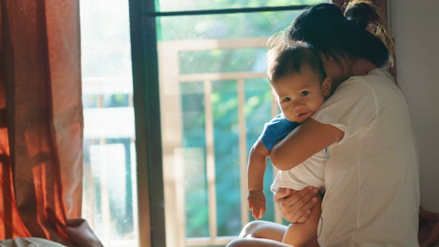 A mother hugging her baby boy tight