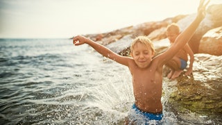 Two autistic boys playing in the sea at a beach