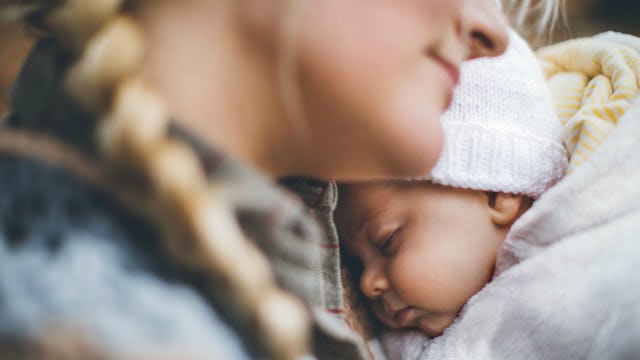 Mom holding her newborn baby with severe hip dysplasia