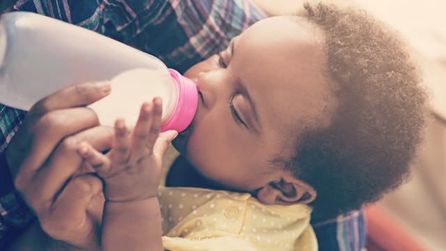 A baby drinking dairy-free milk from the bottle