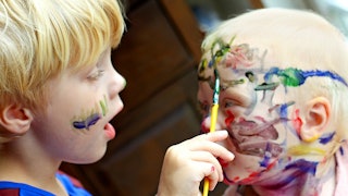 Two blonde boys painting their faces