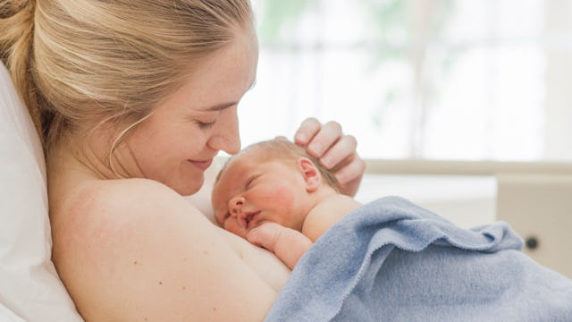 A woman snuggling with her newborn baby 