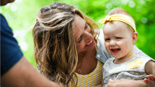 Mother smiling at her kid with special needs 