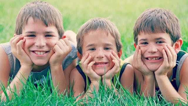 Three boys laying on the grass