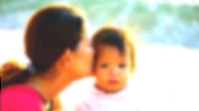 A mom kissing her baby