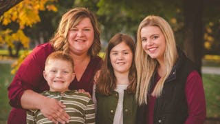 A family of four, mother, two daughters and a son posing for a photo