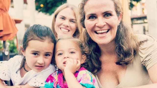 A blonde woman taking a selfie with her three stepdaughters.