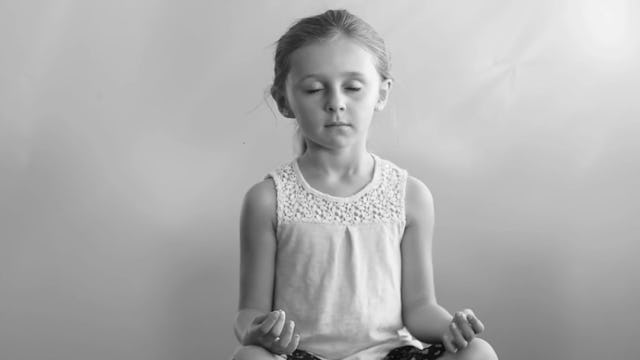 A girl meditating in order to manage her emotions