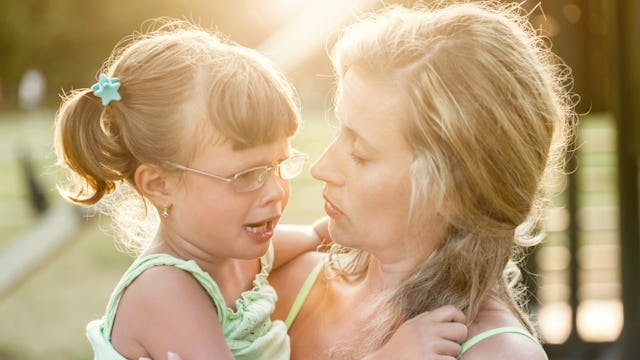 A mother holding her daughter who is experiencing an Autism meltdown