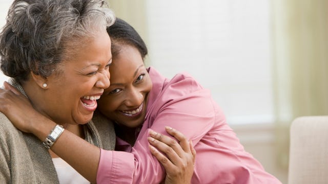 Woman hugging her mom while both of them are smiling