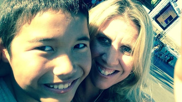 A woman taking a selfie with her adopted teen son