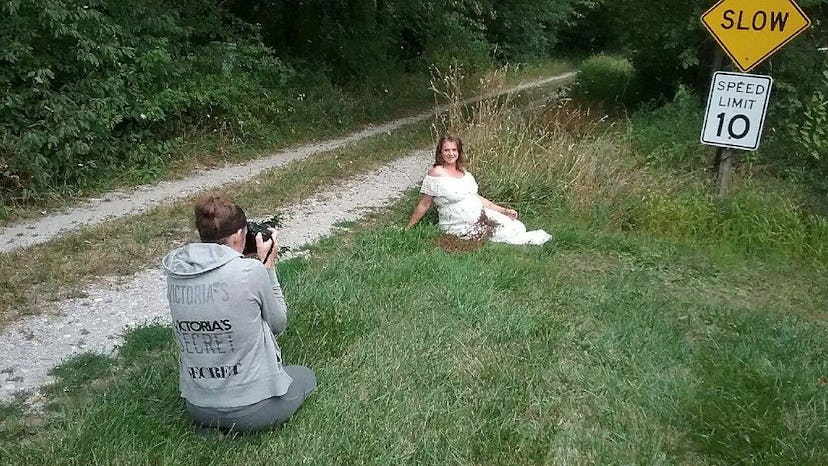 A male photographer is using a professional camera to capture a unique maternity shot in the nature