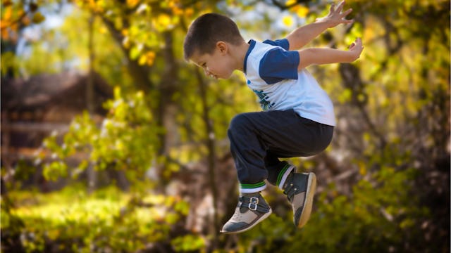 A boy jumping through the air at the park