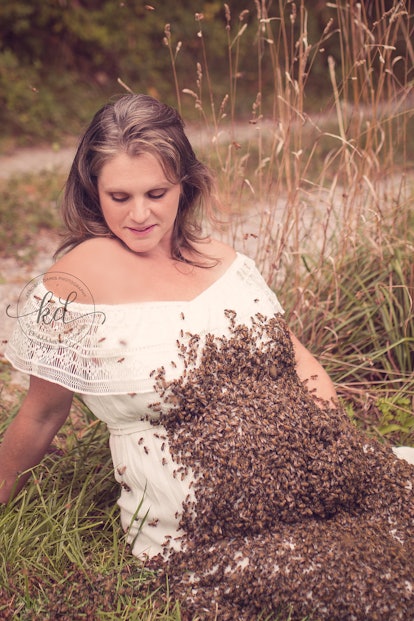 Bees swarming on a pregnant woman's belly for a unique maternity shoot while she is sitting on the g...