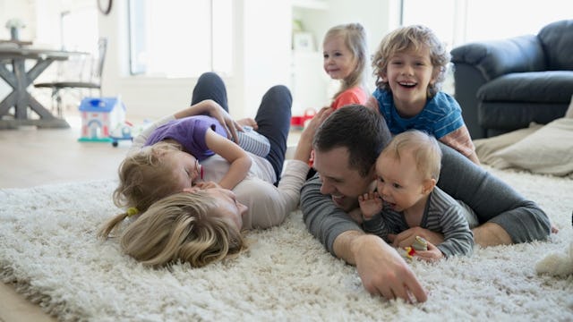 Kids playing on the floor with their father and new stepmom