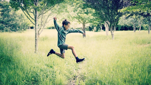 A boy with ADHD running trough a field.