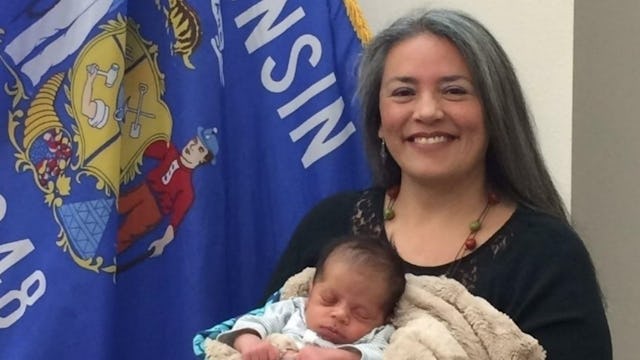 The lawmaker who was banned from public breastfeeding holding a newborn baby in front of the Wiscons...