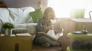 A woman sitting down in her living room while doing 'Swedish Death Cleaning,' the latest declutterin...