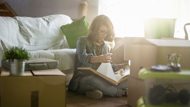 A woman sitting down in her living room while doing 'Swedish Death Cleaning,' the latest declutterin...