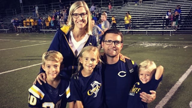Emily Holweger with her husband and three kids in jerseys on a football field