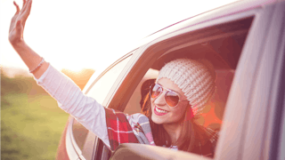 A girl waving through a car window
