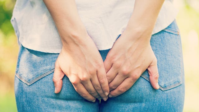 A woman about to have a colonoscopy with her hands on her behind