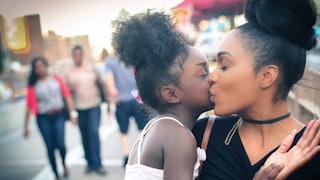 Mother kissing her child on the street 