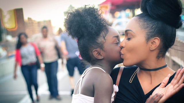 Mother kissing her child on the street