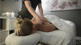 A woman laying face-down getting a massage.