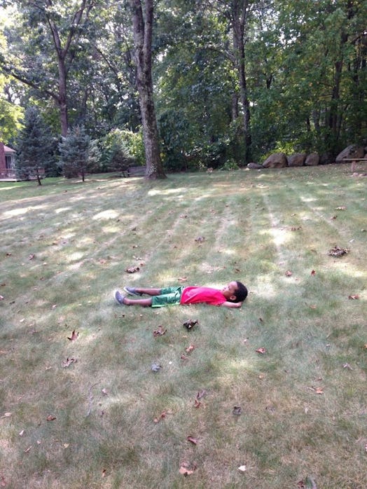 Lauren Jordan's son lying on grass surrounded by trees