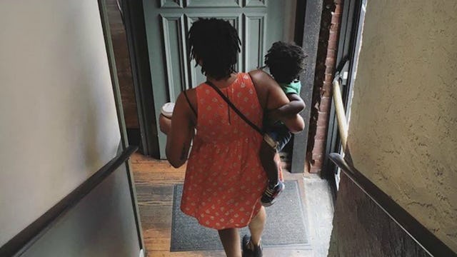 A woman in a red dress leaving her husband and taking her child with her walking down a staircase