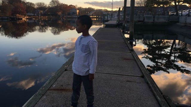 Lauren Jordan's son standing and looking at the lake 