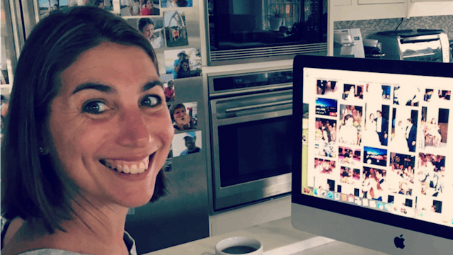 Zibby Owens smiling and working on a computer in the kitchen