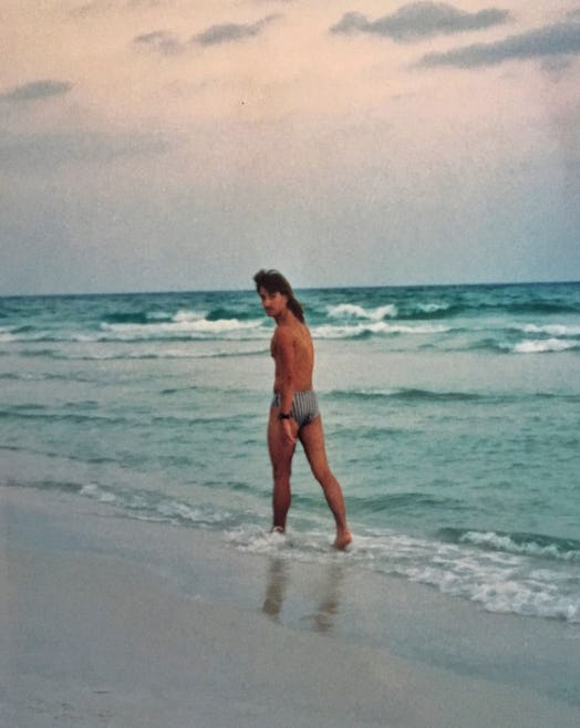 A man walking down Panama City Beach in swim trunks