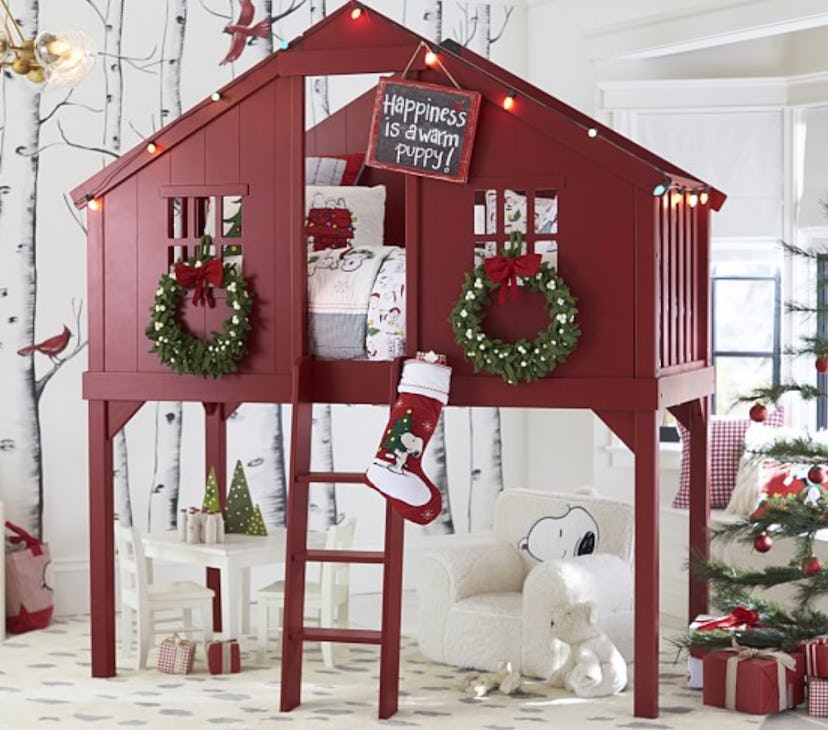 A red tree house loft bed next to a Christmas tree and various Christmas decorations