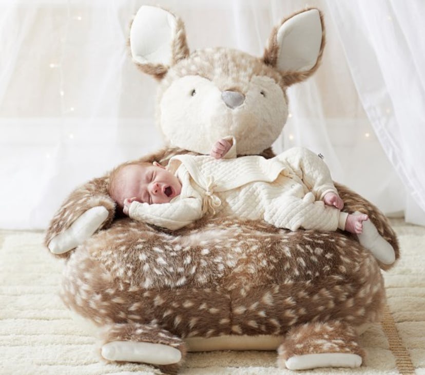 A brown critter chair with a newborn baby sleeping on it