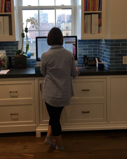 Zibby Owens standing in her kitchen and working on a computer