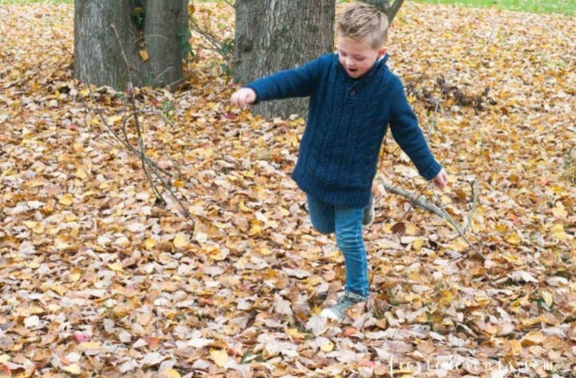 Misty Nelson's son running and playing around fallen leaves in a park