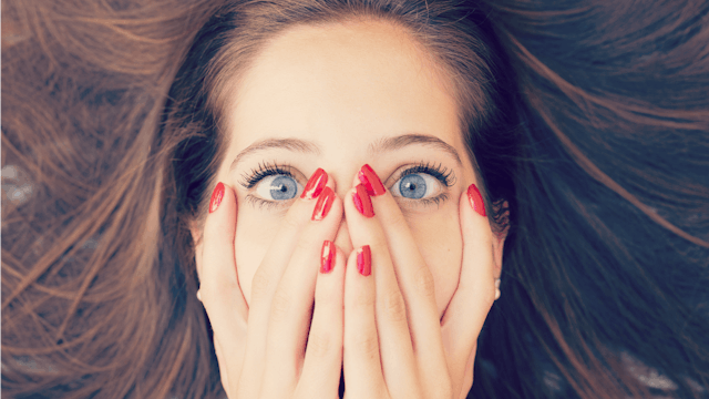 Woman shockingly covers face with her hands