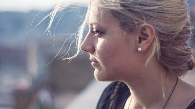 A person with depression looking into the distance with wind in hair
