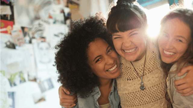 Three happy women posing hugged for a photo who thing it's time to end the 'Catty Women' stereotype