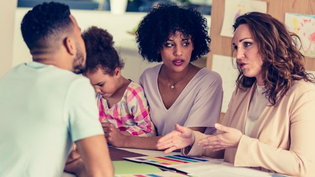 Two parents and their daughter at an IEP meeting with the students teacher