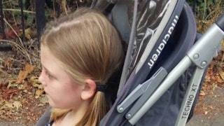 5-year-old blonde girl with pigtails sitting in a stroller
