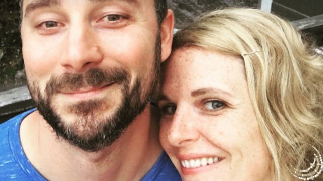A selfie of a married couple: blonde woman and black-haired man with beard