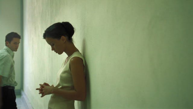 Emotionally exhausted woman standing in the hallway while her partner is walking away