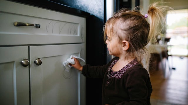 A little girl cleaning a commode