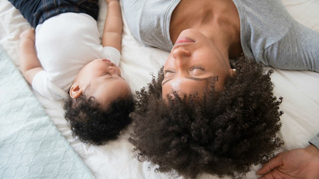 A mother enjoying co-sleeping with her baby in bed