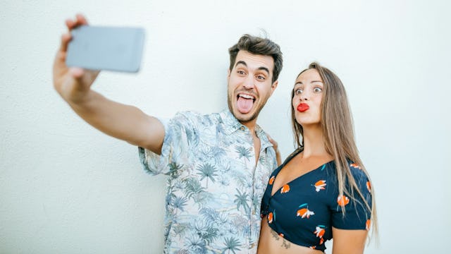 Couple taking a selfie to post on their shared Facebook account