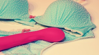 A pink vibrator placed on women's blue underwear