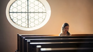 A girl sitting in the last pew in a church who has been taught religious abstinence which has instil...